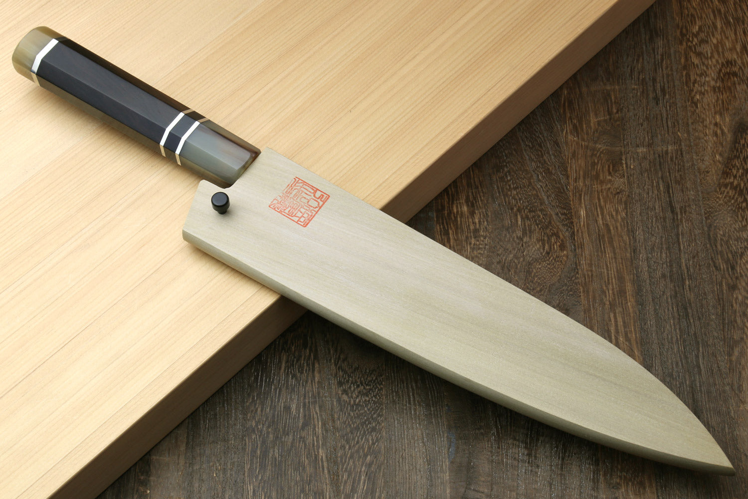 Gyuto chef knife angled view showing ebony handle and long stainless blade