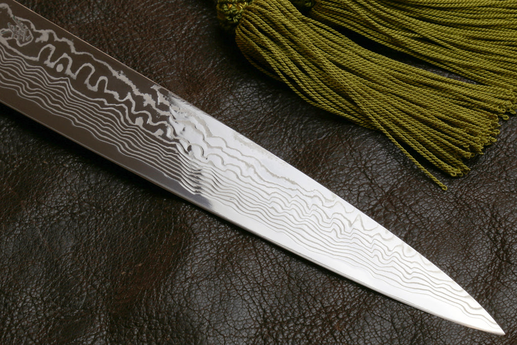 Sujihiki slicer knife blade, white-gray damascus finish along dark spine