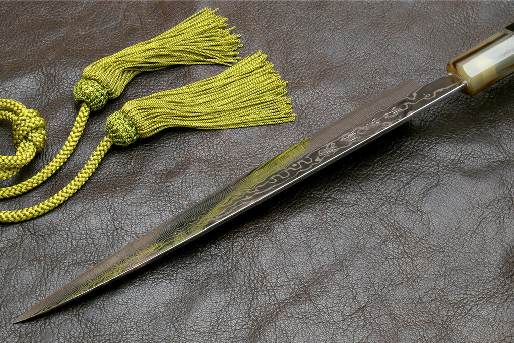 Sujihiki slicer knife with damascus steel blade and triple-ring dark handle, back view