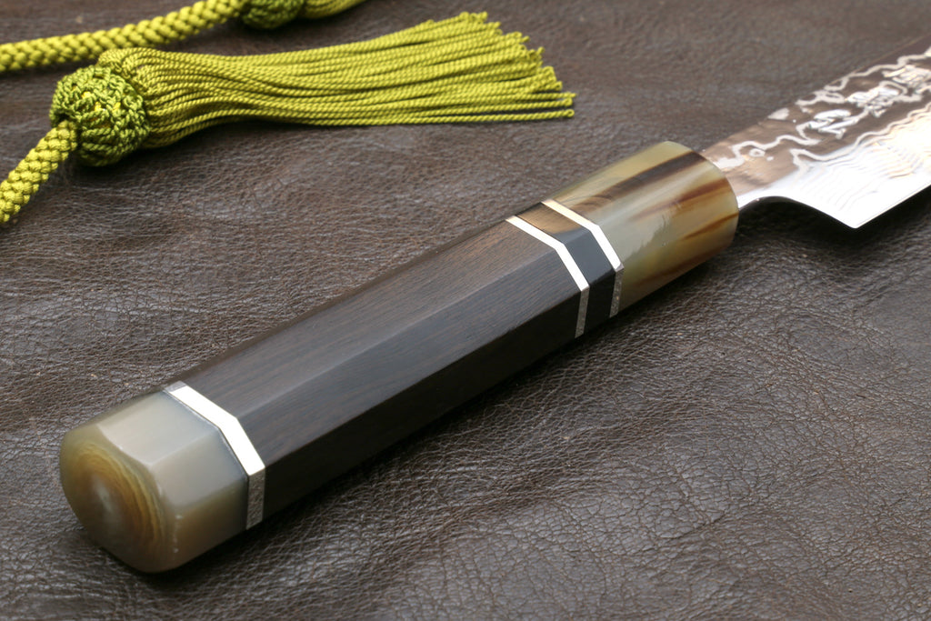 Sujihiki slicer knife handle close-up with dark ebony grip and striped collar accents