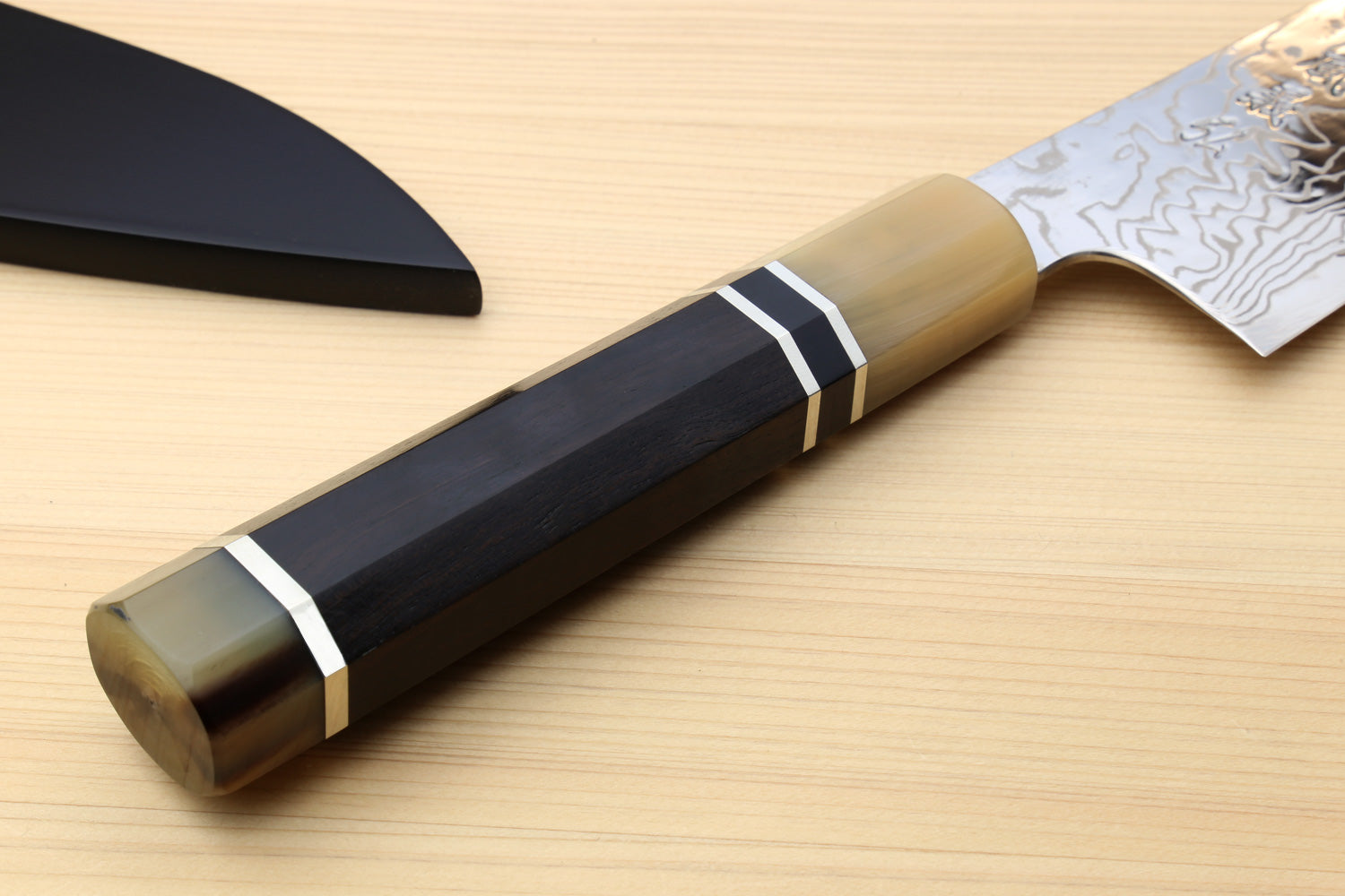Damascus gyuto chef knife with handle close-up and triple ring accents