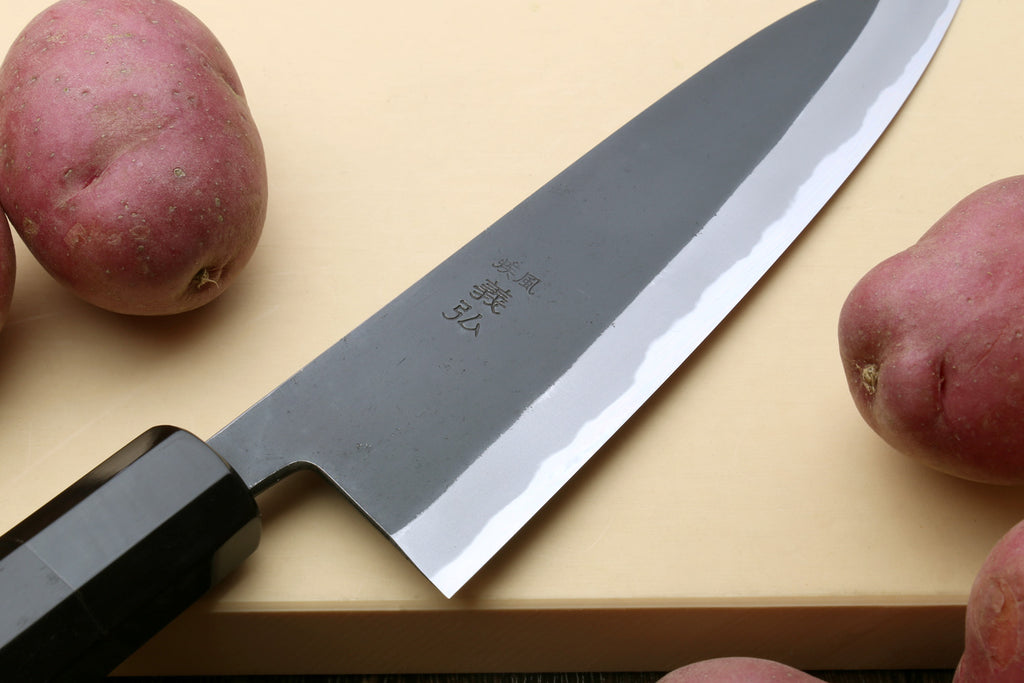 Japanese gyuto knife close-up of kurouchi blade and white cutting edge