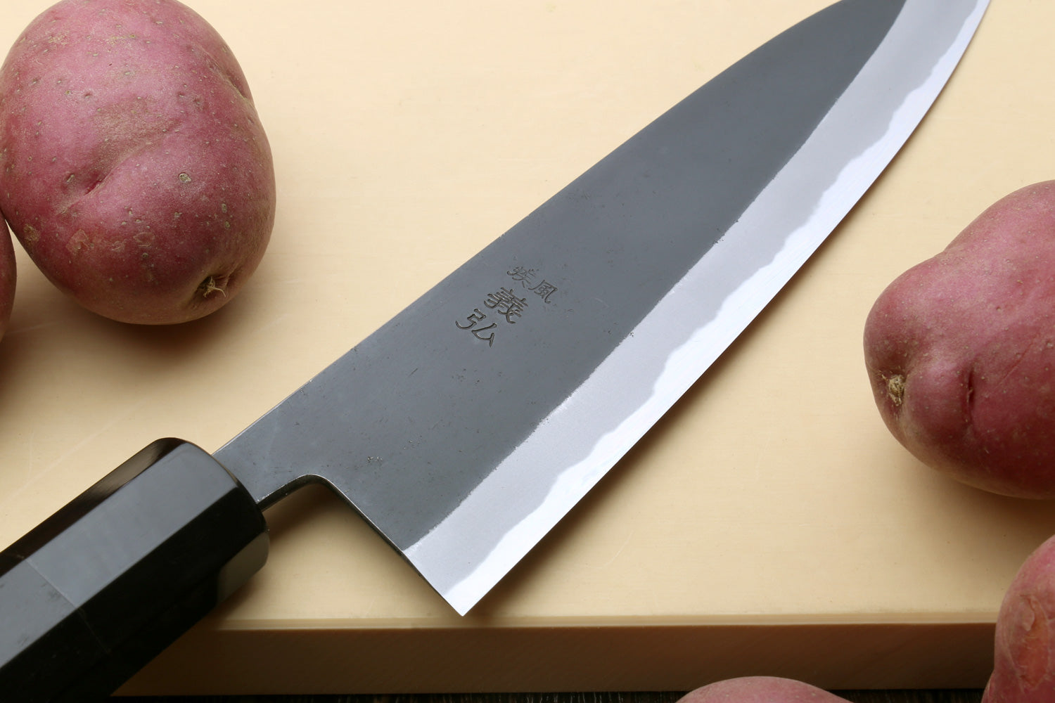 Japanese gyuto knife close-up of kurouchi blade and white cutting edge