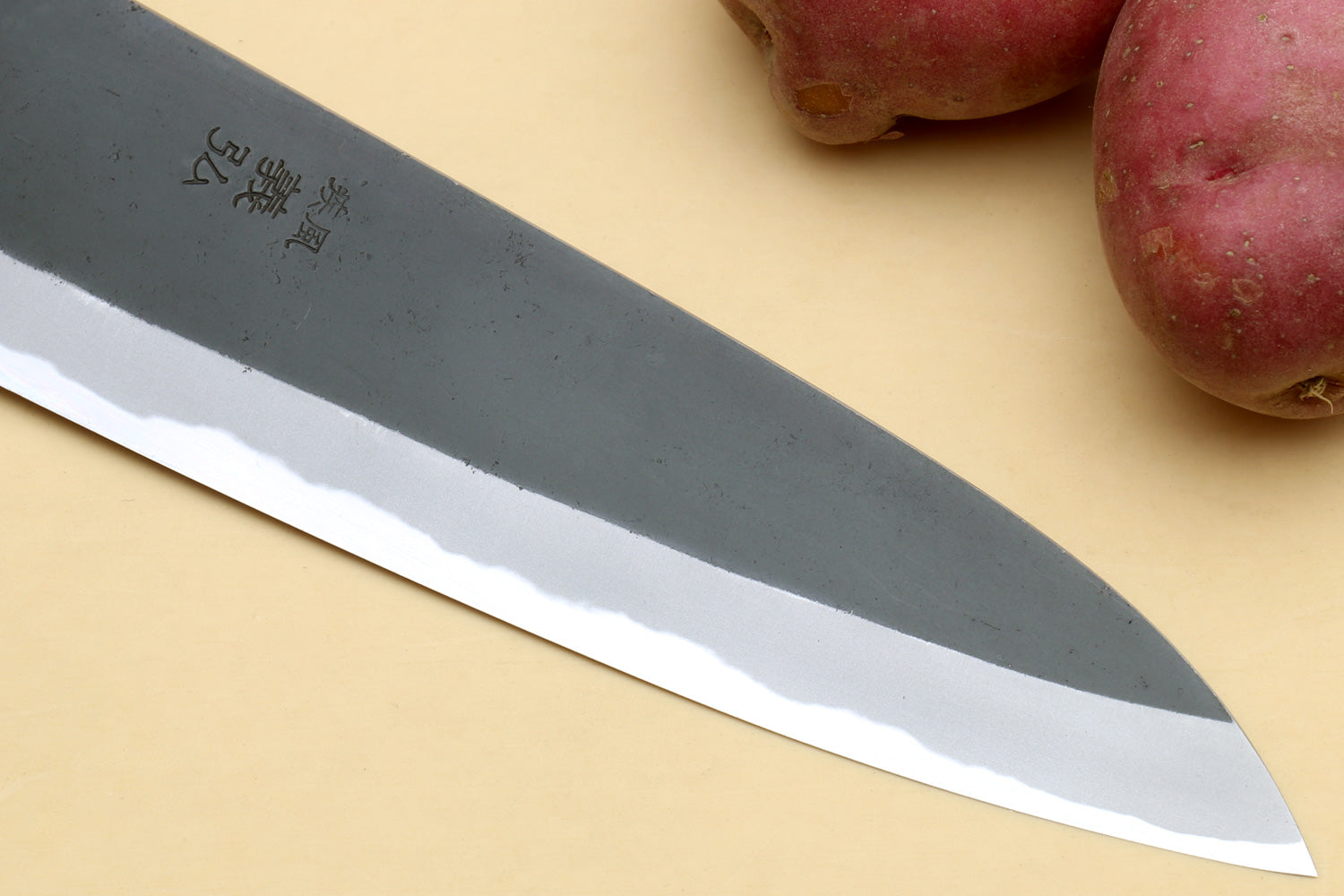 Japanese gyuto knife close-up of engraved blade and pointed tip