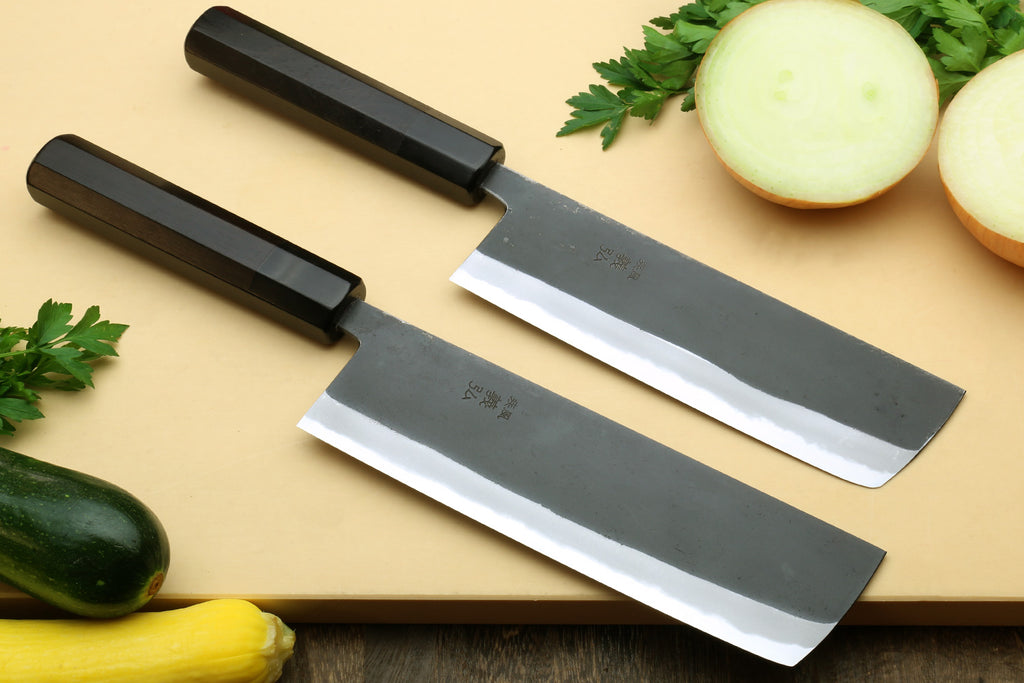Two nakiri vegetable knives with black handles and dark steel blades