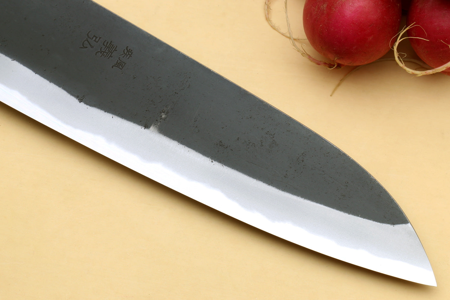 Santoku knife close-up of dark blade tip and reflective cutting edge