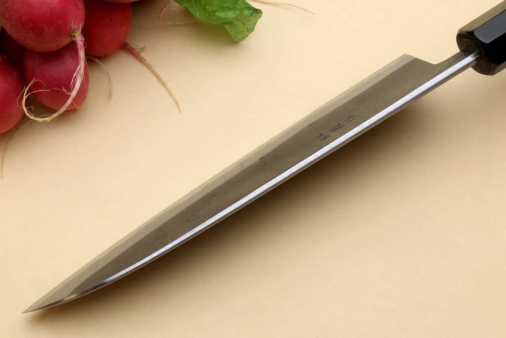 Santoku knife side view with pointed tip and dark blade finish