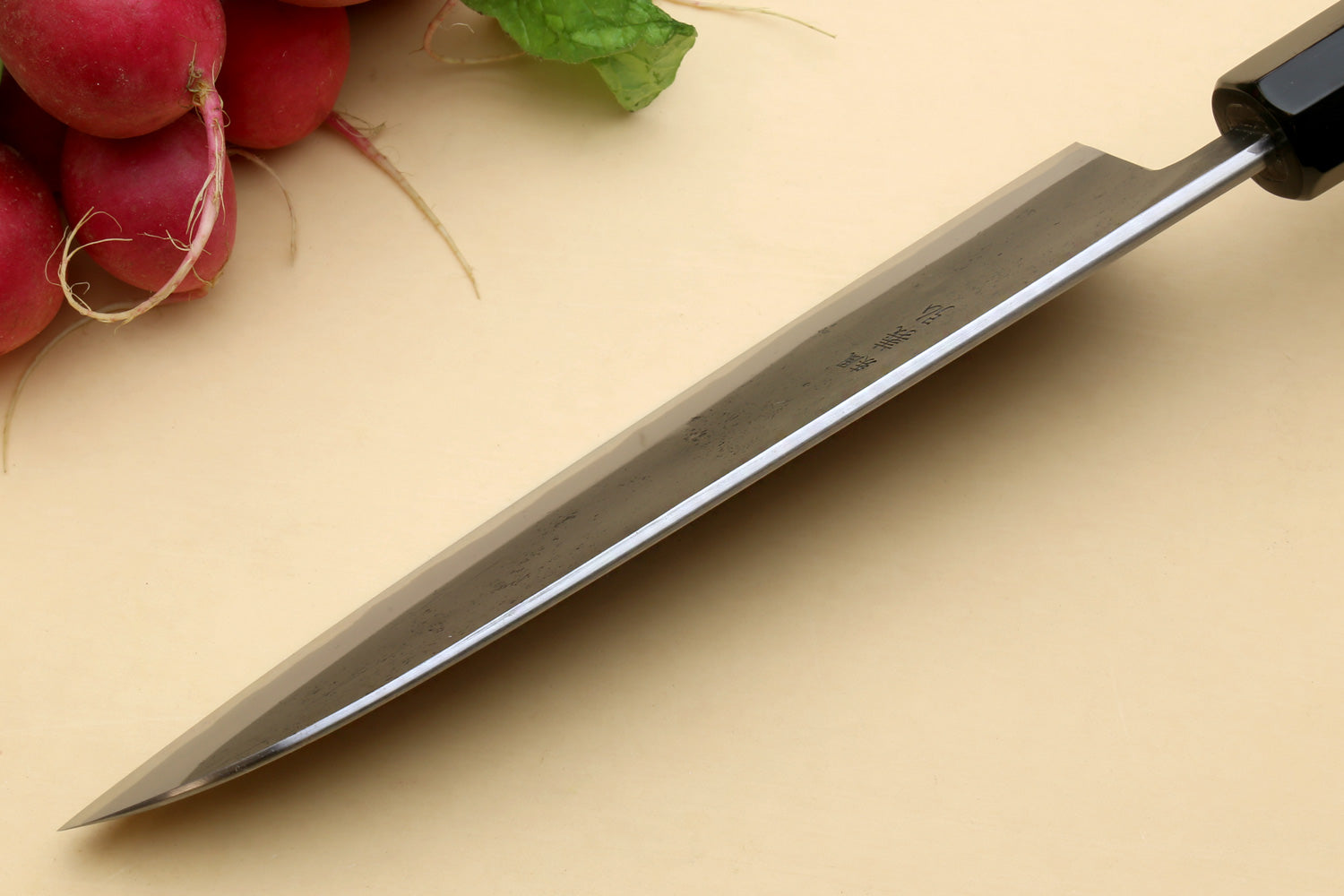 Santoku knife side view with pointed tip and dark blade finish