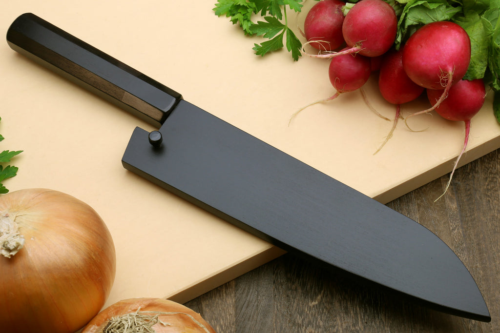 Santoku knife with dark blade and black handle cover on a cutting surface