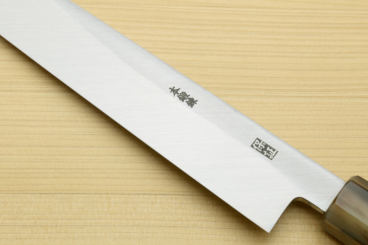 Yanagi sushi knife blade close-up with dark handle