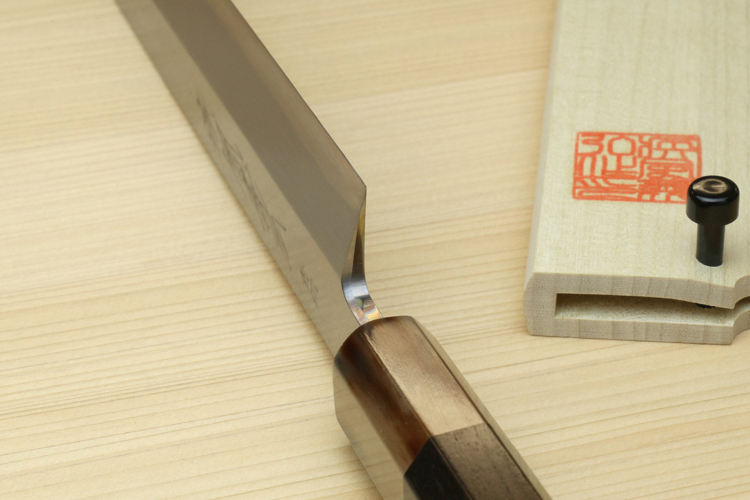 Yanagi sushi knife edge view with dark handle and wooden saya