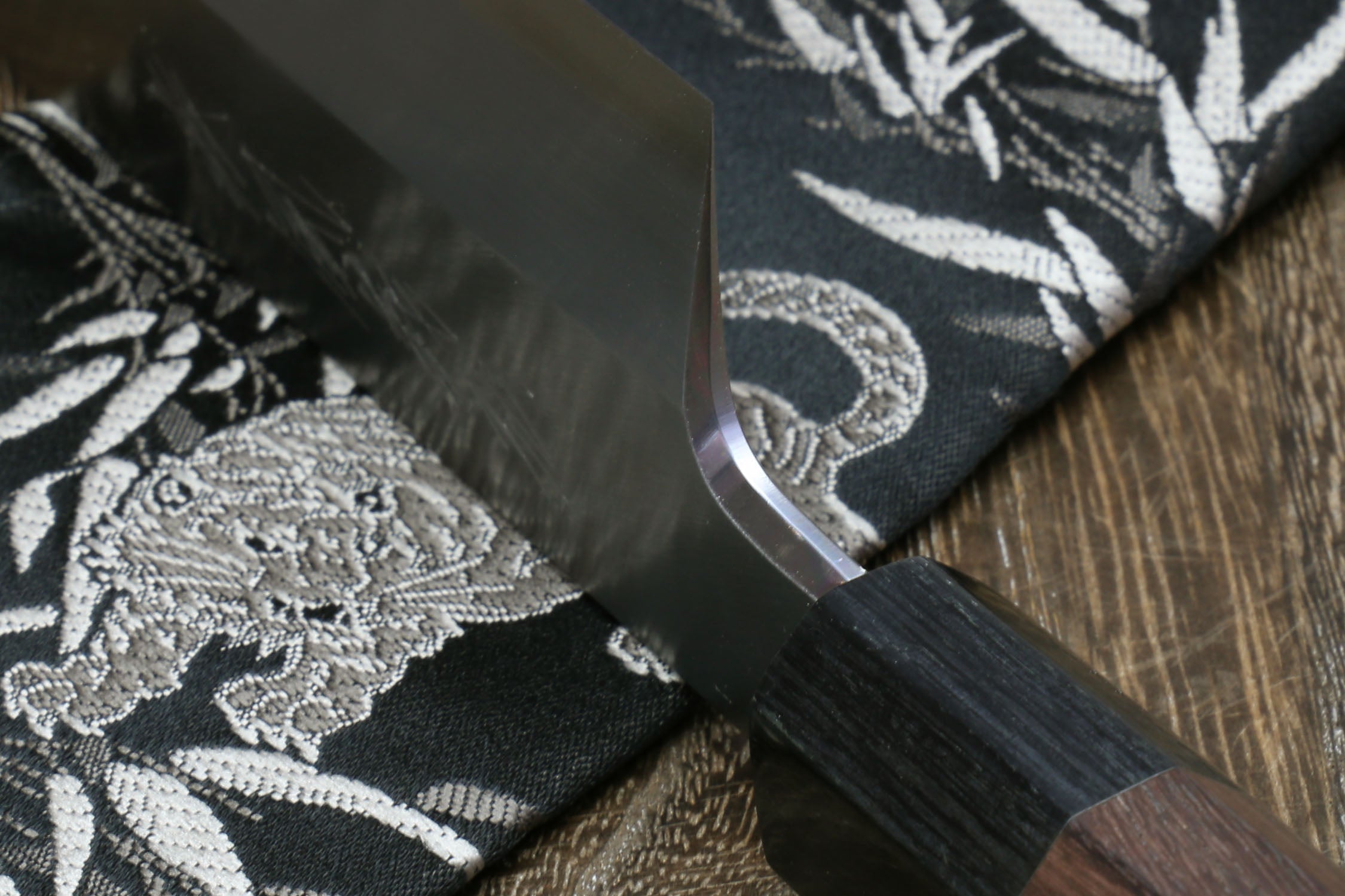 Japanese kama usuba knife blade edge and dark handle, close-up of cutting edge.