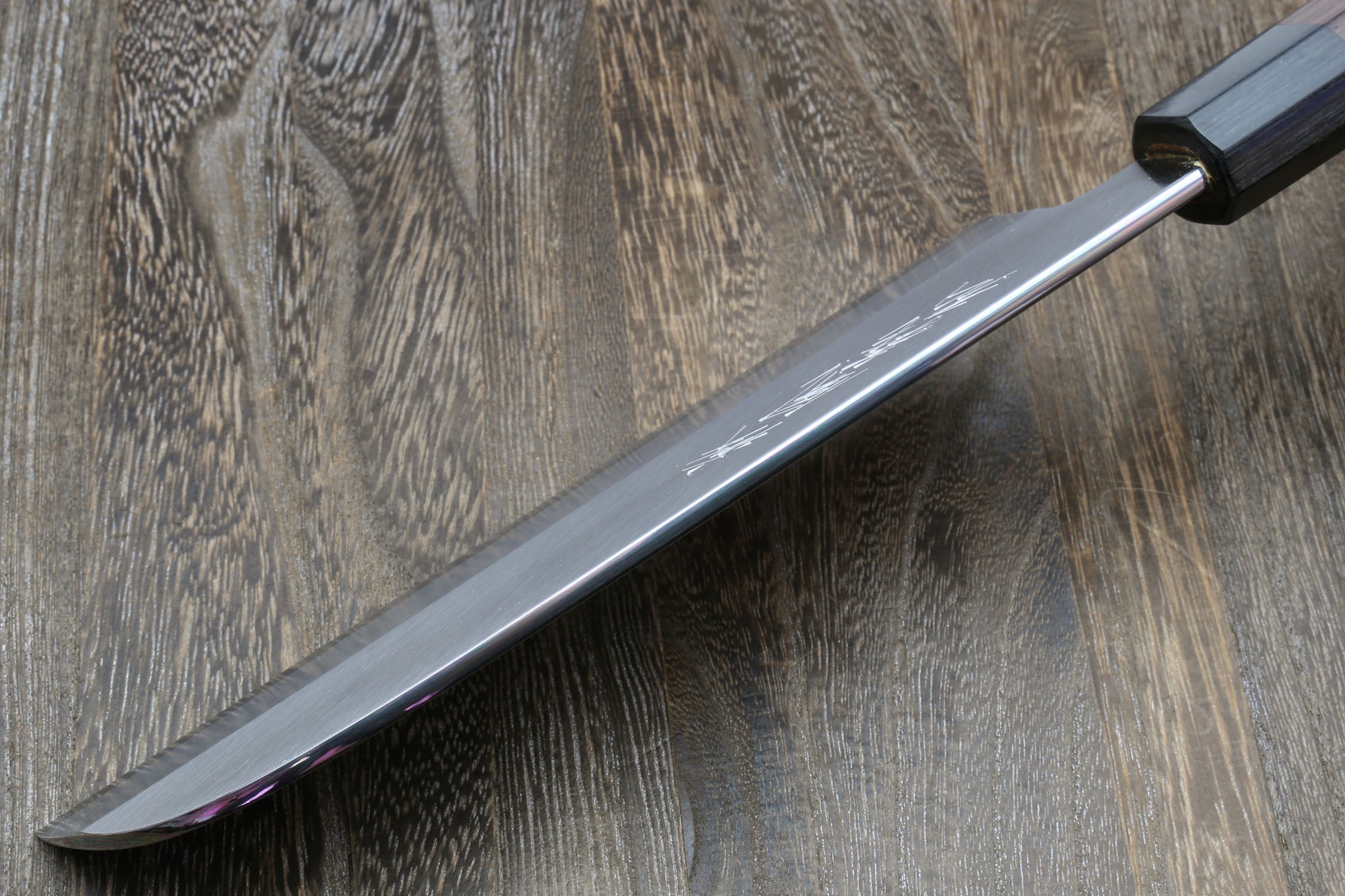 Japanese kama usuba knife with light blade and dark shitan handle, angled close view.