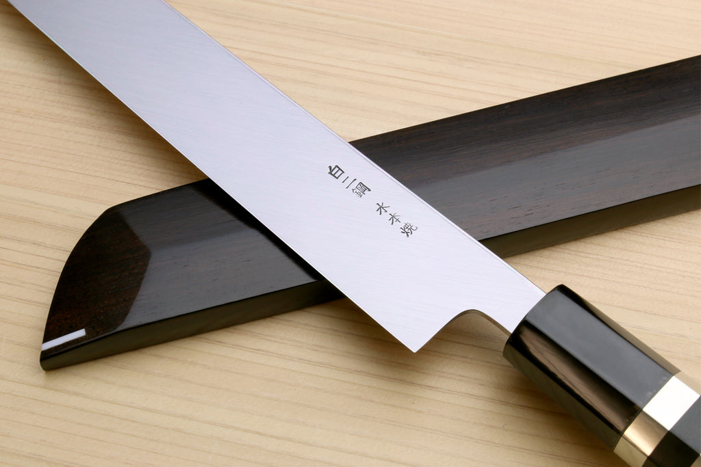 Japanese sushi knife with mirror-finished white blade, ebony handle, and saya