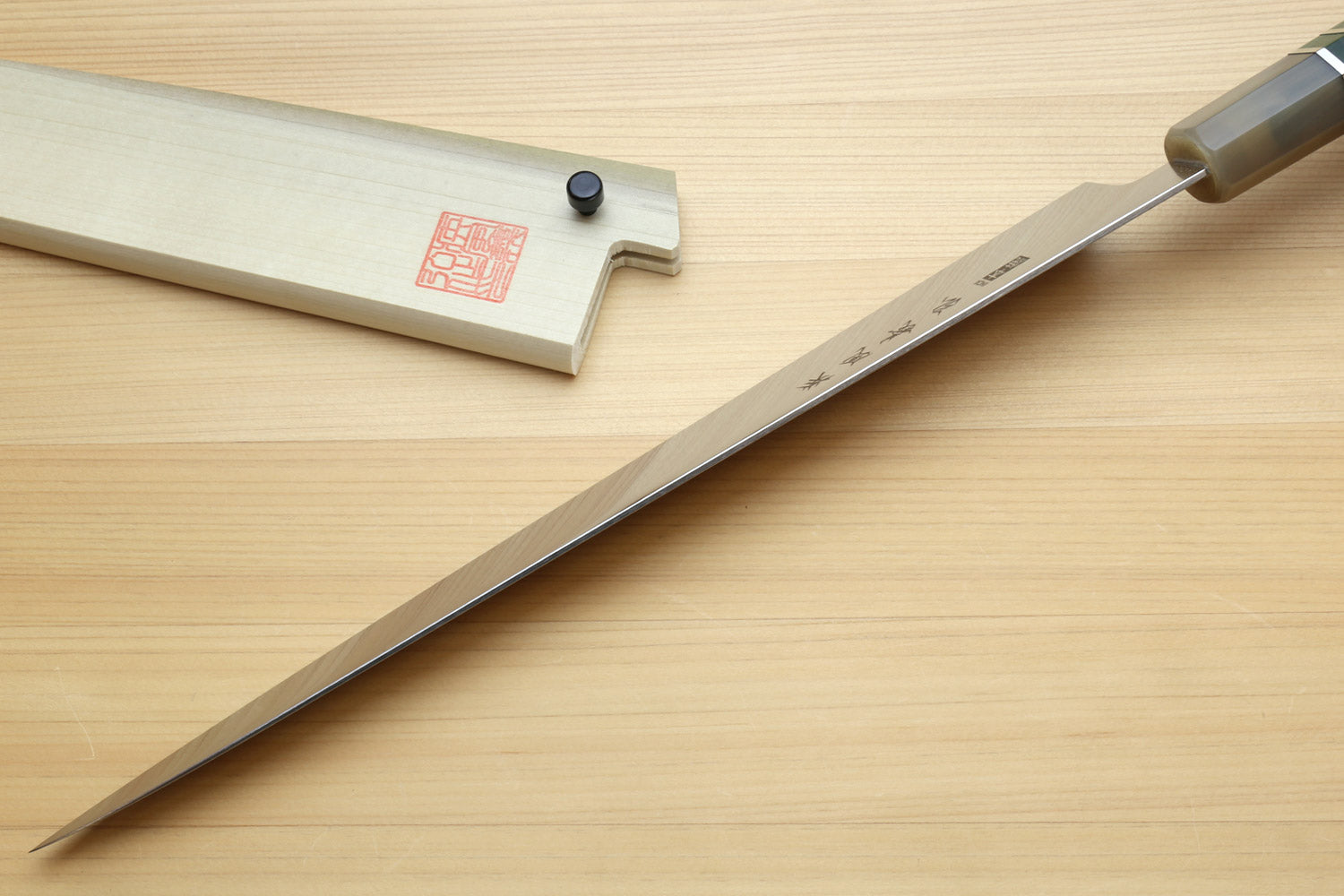 Sujihiki slicer knife with long silver blade and dark green handle