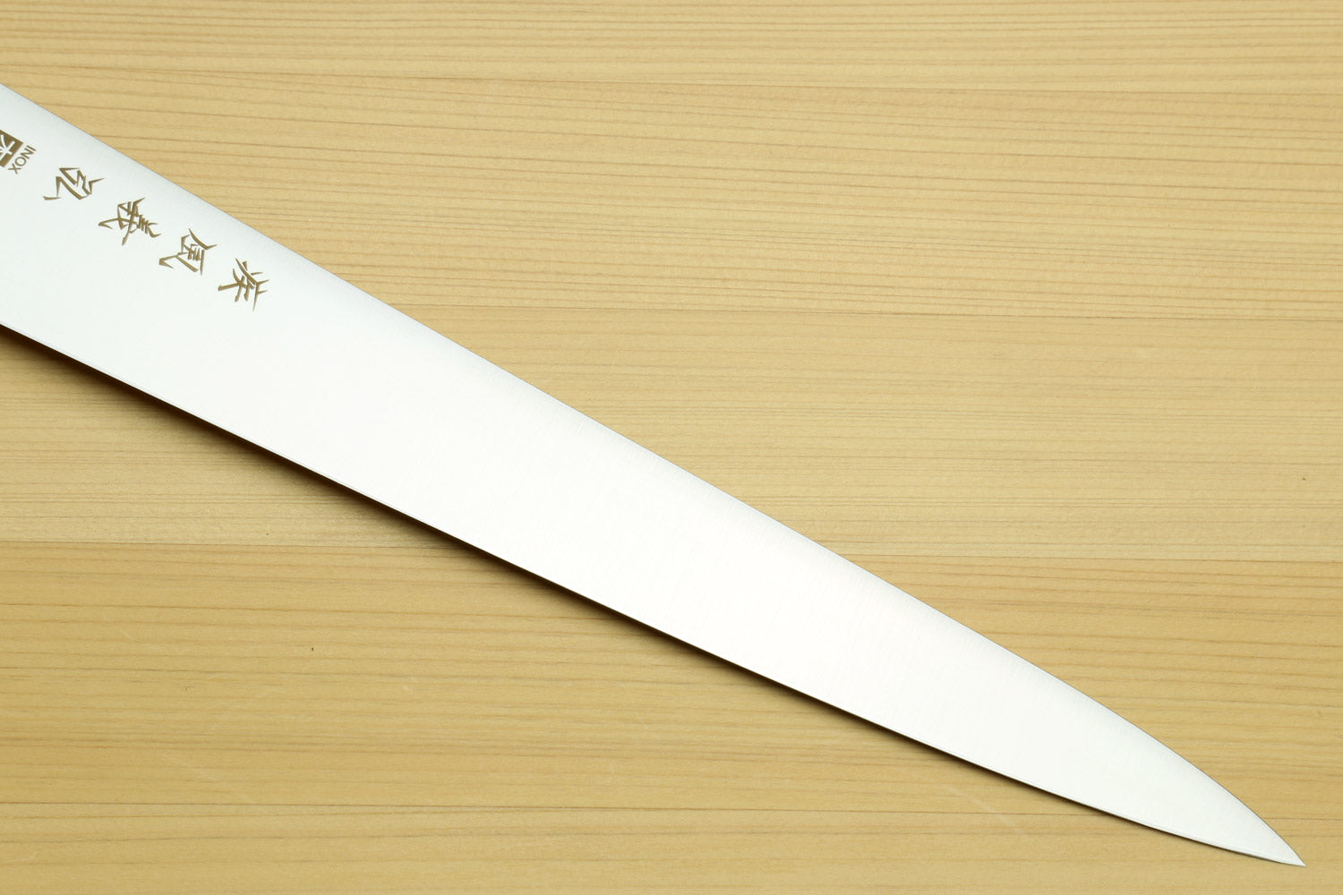 Sujihiki knife blade close-up with engraved characters on white steel