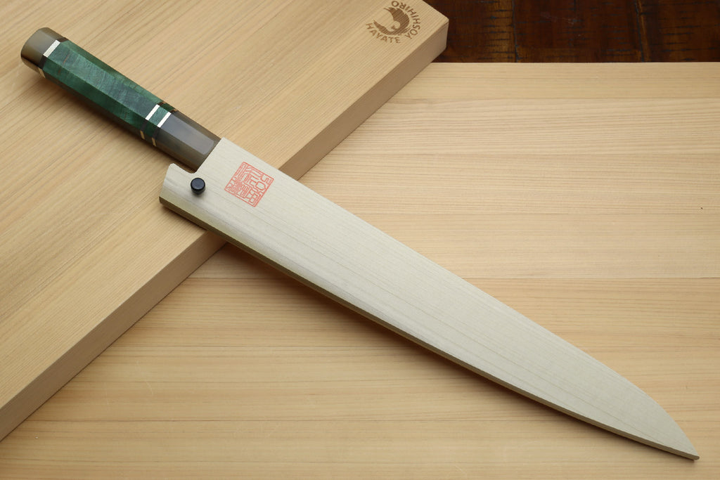 Sujihiki slicer knife with wooden saya and dark green handle on wooden surface