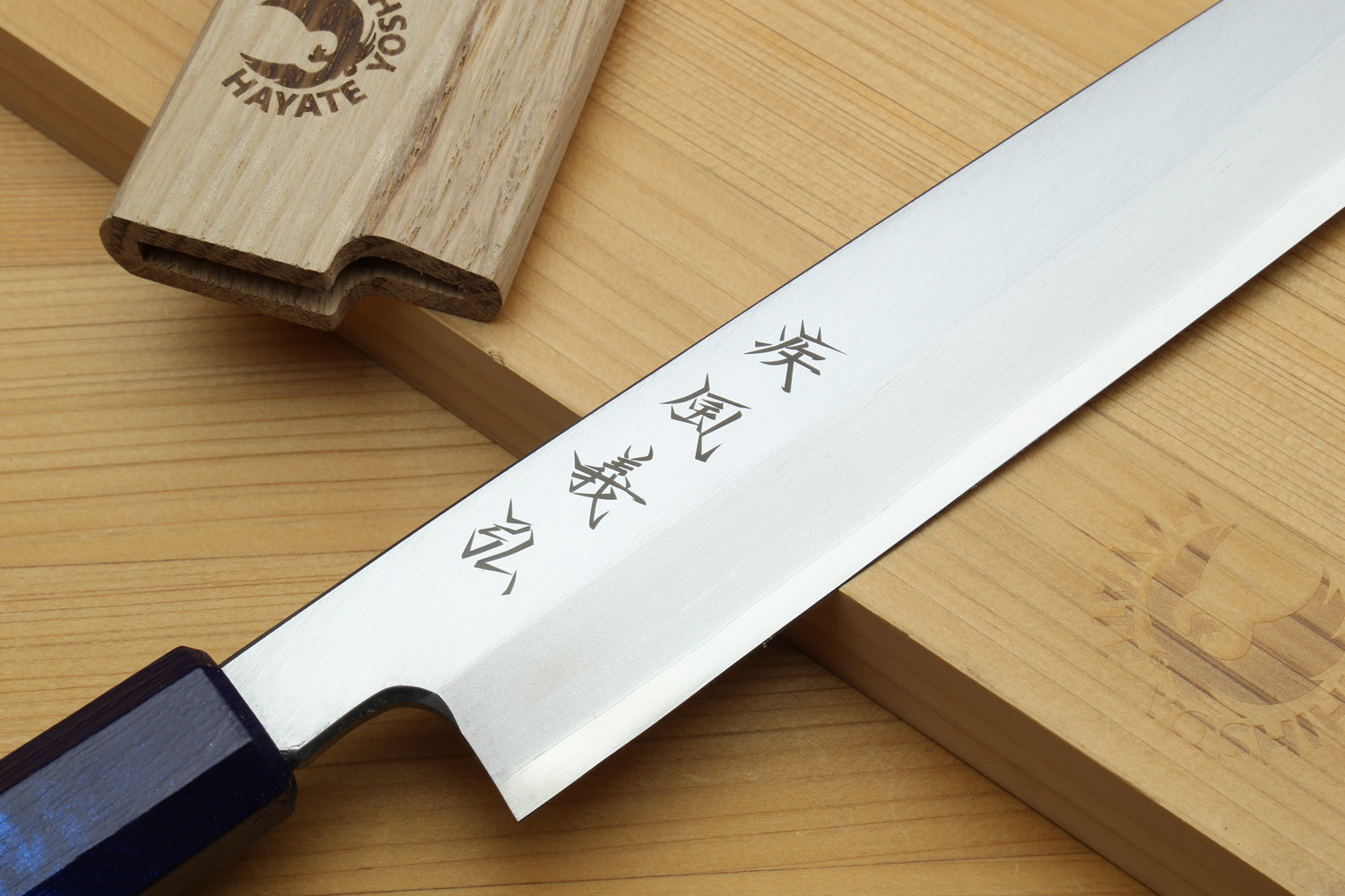 Yanagi sushi knife blade close-up with Japanese characters and dark-blue handle