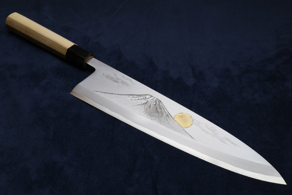 Deba fish fillet knife with white blade, gray etching, and gold medallion, wood handle