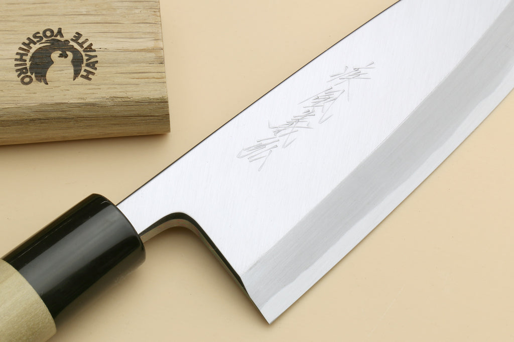 Deba fish fillet knife with dark handle, light bolster, close-up of steel blade