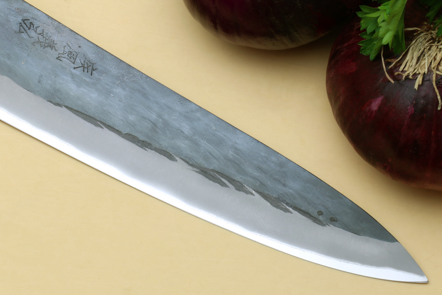 Gyuto chef's knife tip close-up with blue steel blade and black handle