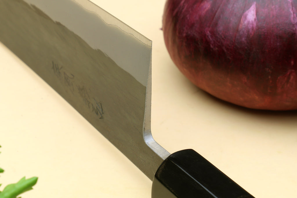 Chef's gyuto knife heel and blade close-up with black handle