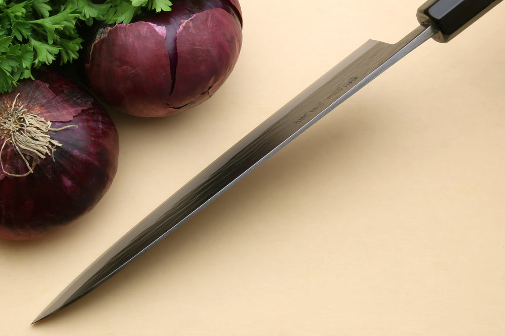 Gyuto chef's knife with black handle and blue steel blade, diagonal view