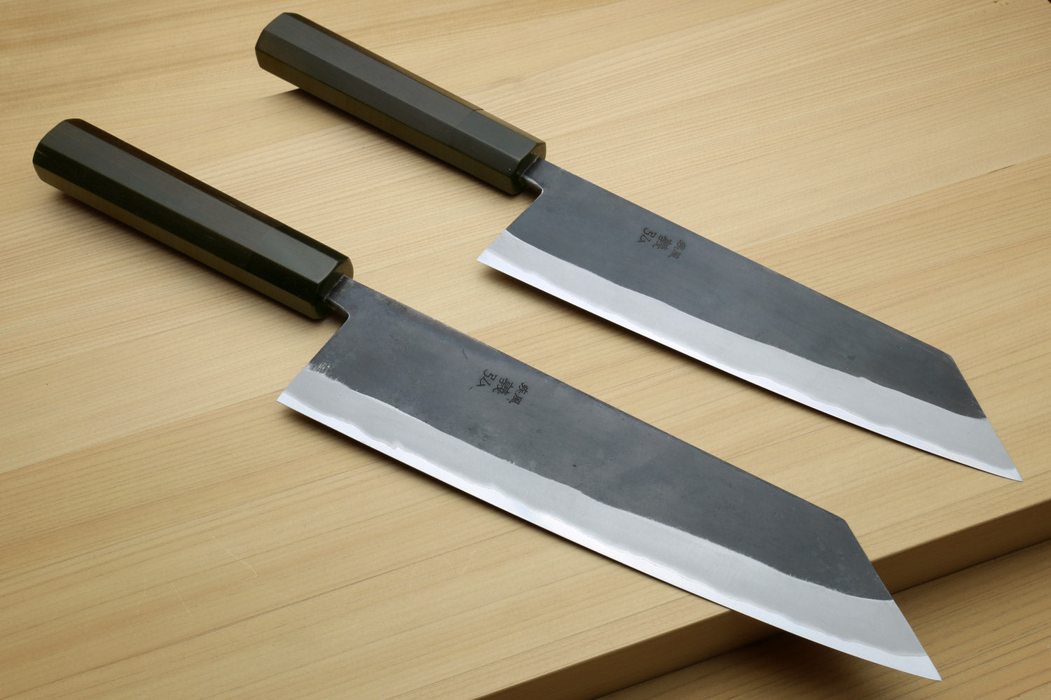 Kiritsuke chef knife with ebony handle, shown with two black saya covers