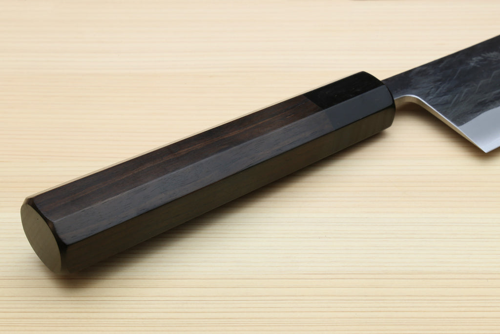 Kiritsuke chef knife handle close-up with dark scales and blue-gray blade