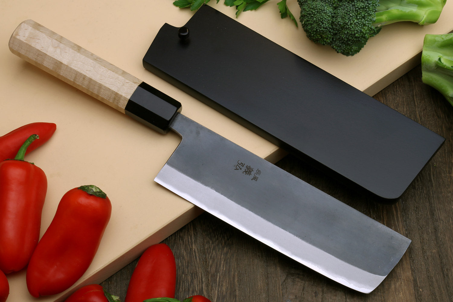 Japanese nakiri knife with black handle and gray blade, straight cutting edge