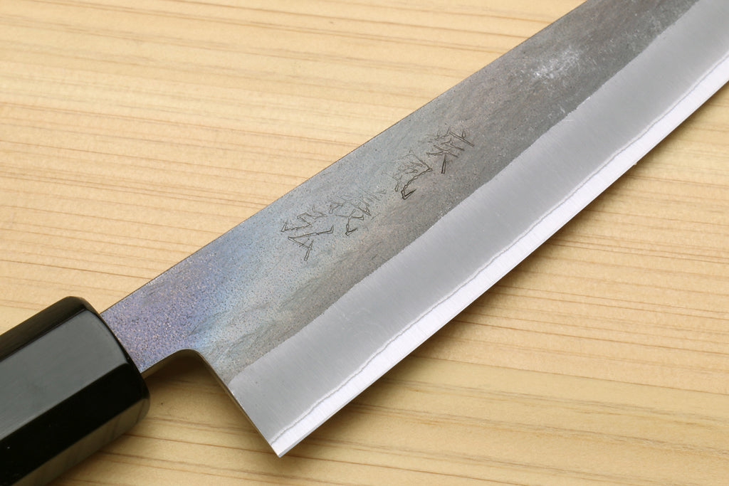 Utility knife blade close-up with blue-grey hammered finish and dark handle