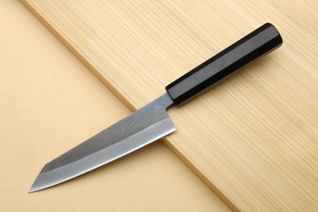 Ebony-handled knife with slim pointed blade and visible bevel, angled