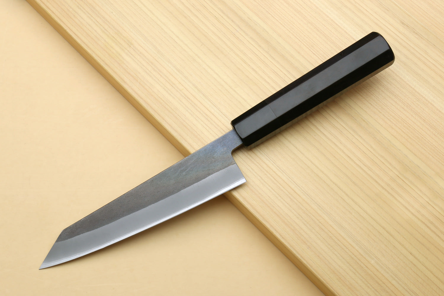 Ebony-handled knife with slim pointed blade and visible bevel, angled