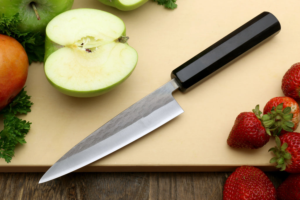 Santoku-style knife with black handle and stainless blade, straight cutting edge