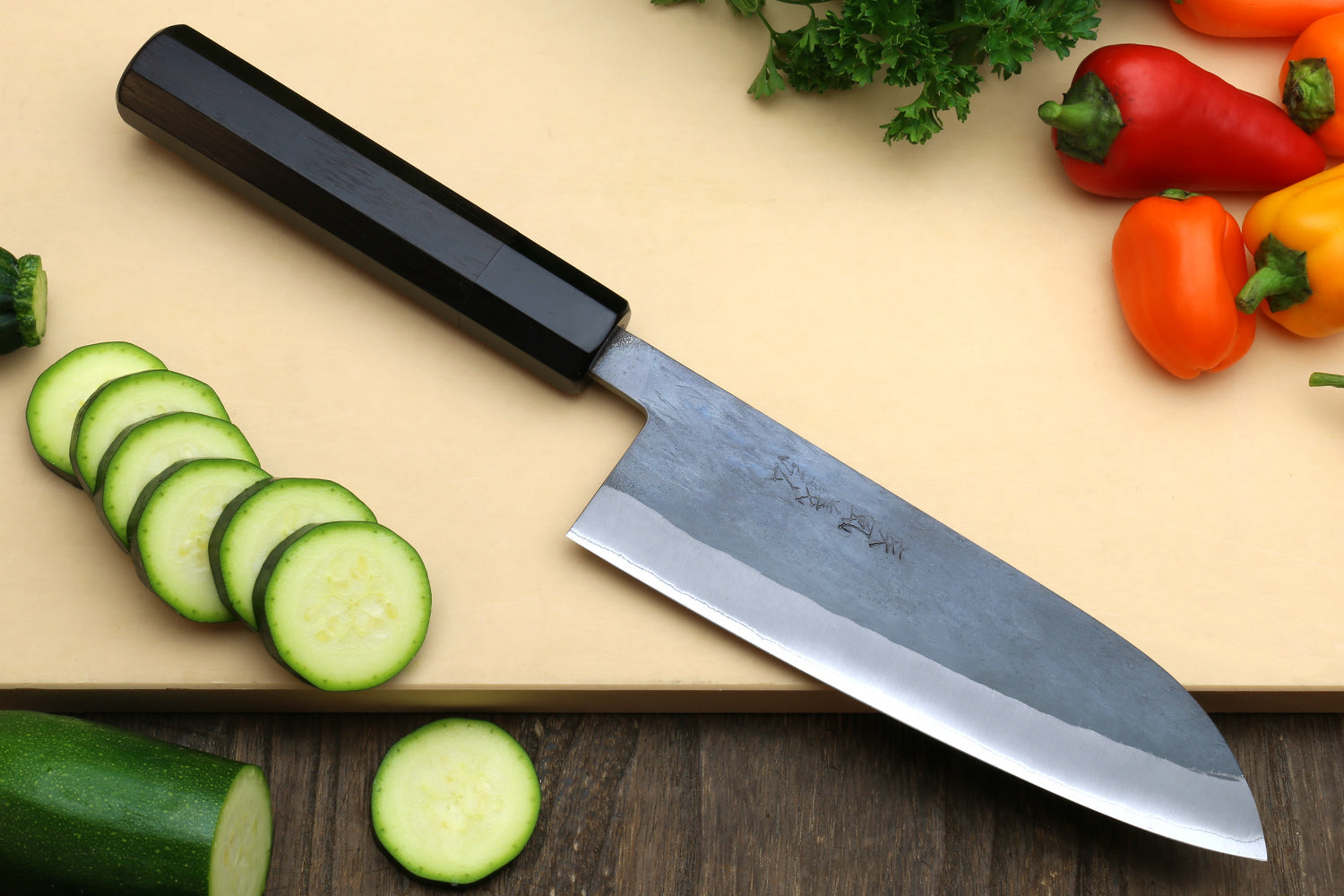 Ebony-handled santoku knife with blue steel stainless clad blade, side view