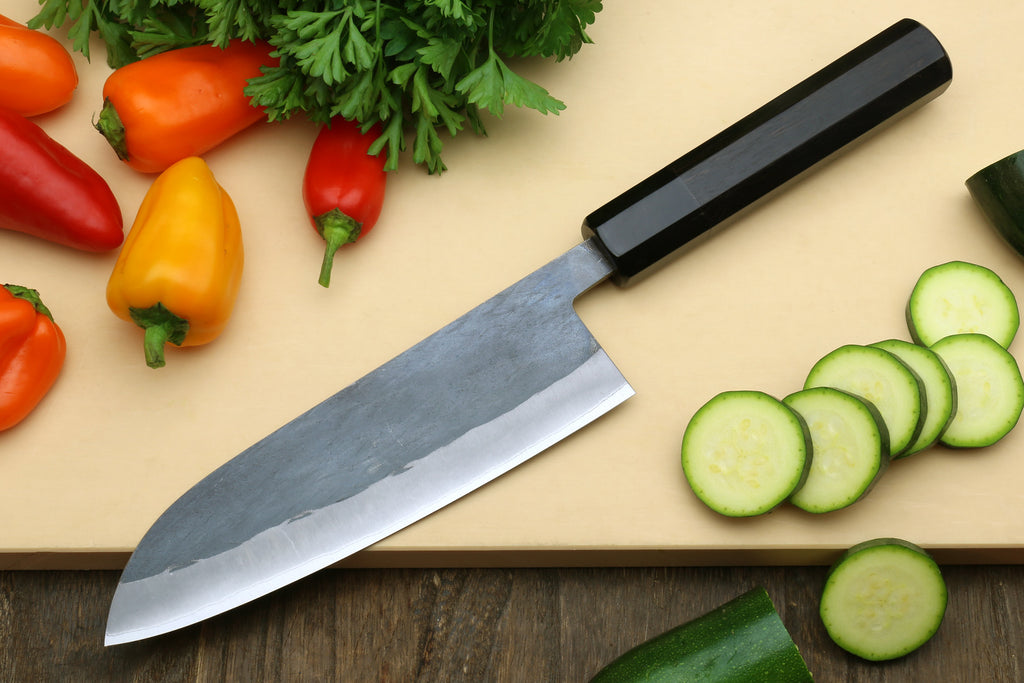 Ebony-handled santoku knife with long blade and polished edge, diagonal view