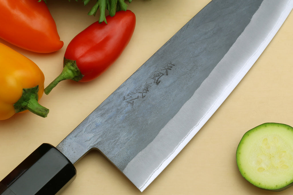 Santoku knife blade close-up with blue-gray finish and ebony handle end