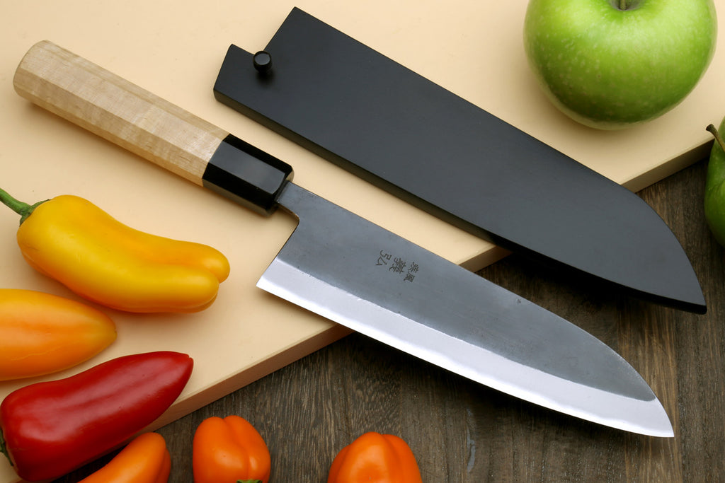 Santoku knife with stainless blade and black sheath on board