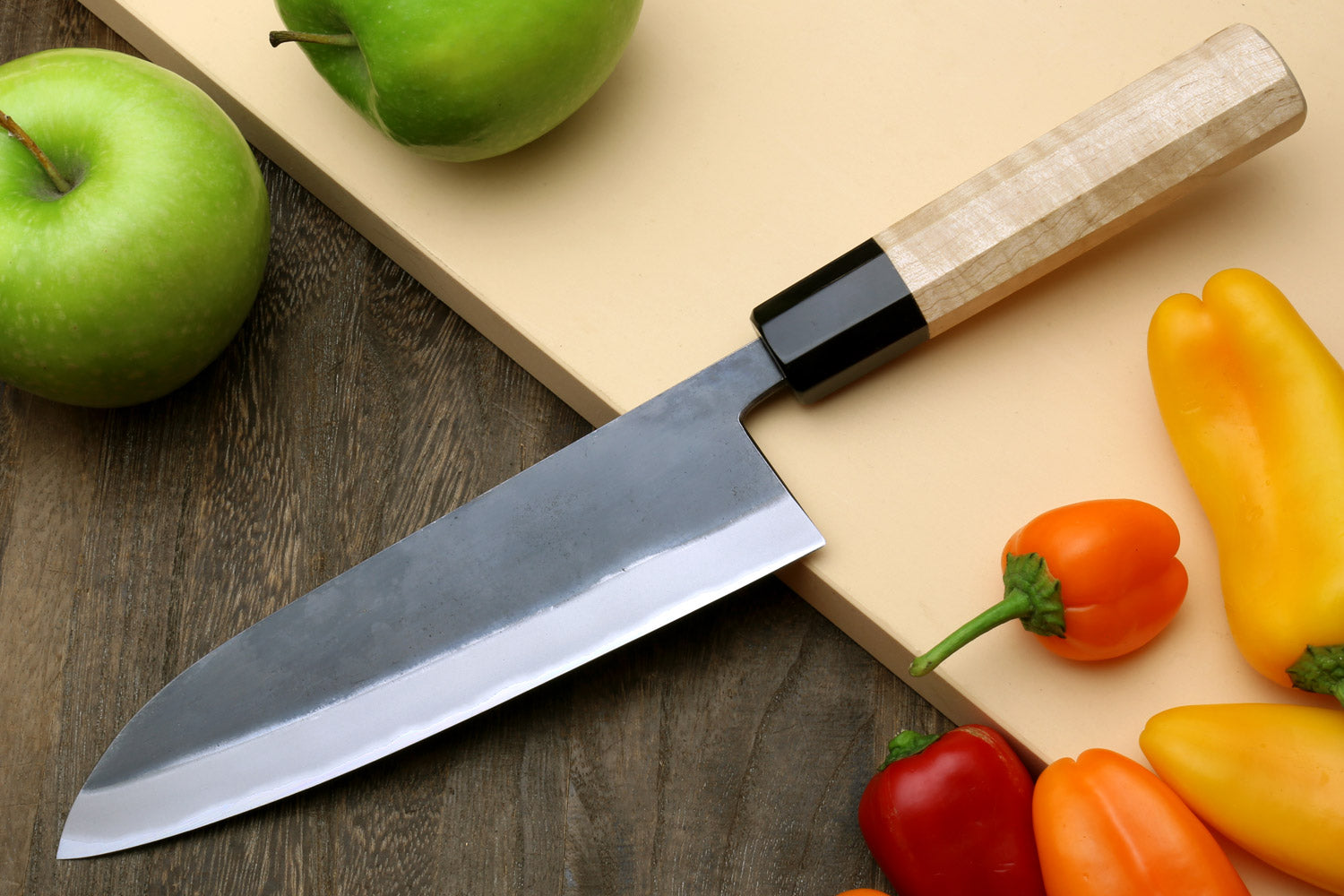 Santoku knife angled view with stainless blade and light wood handle