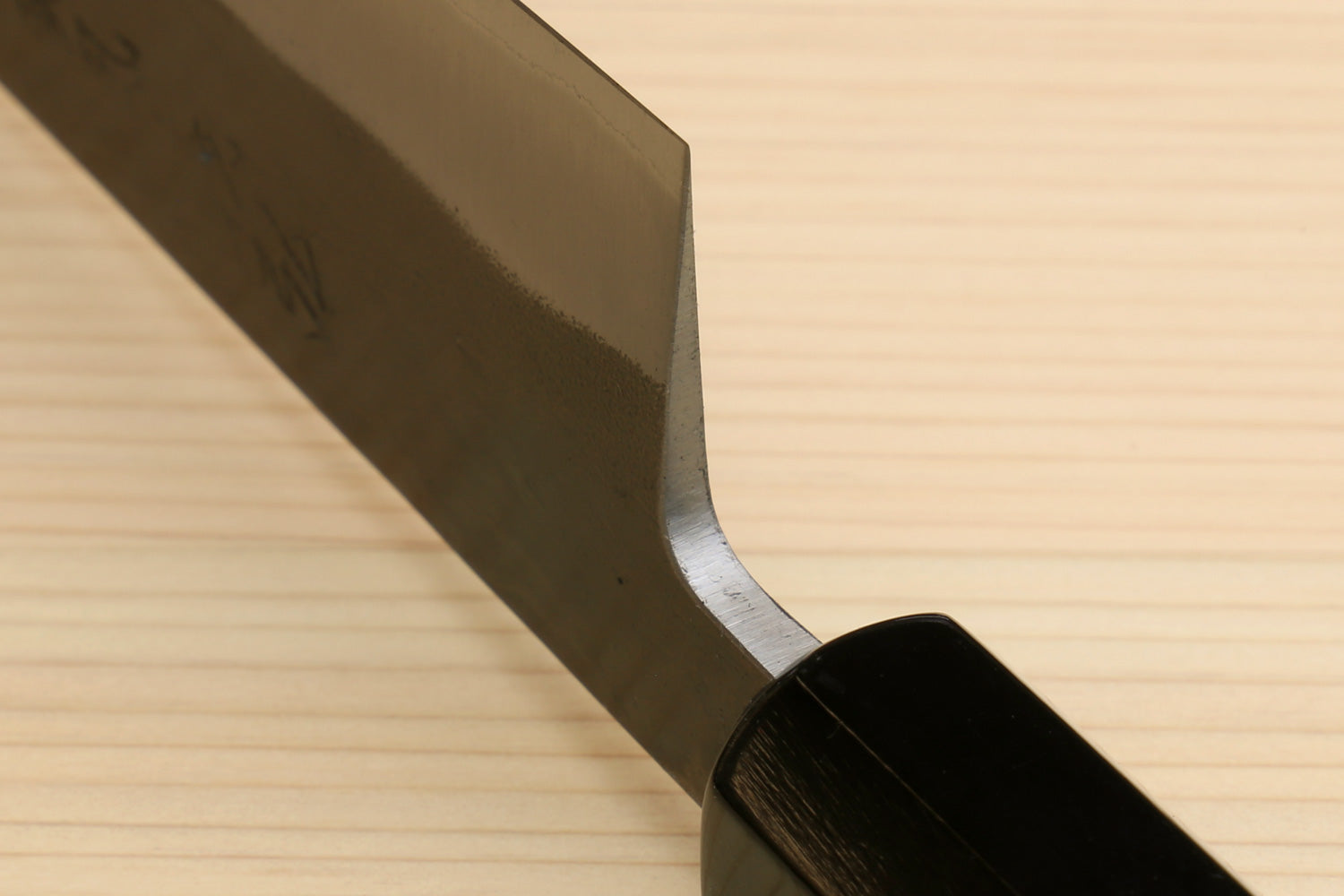 Kiritsuke slicer knife showing blade heel curve and dark ebony handle.