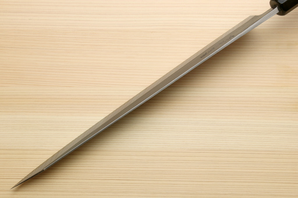 Sujihiki slicer knife in profile with long silver blade and dark ebony handle.