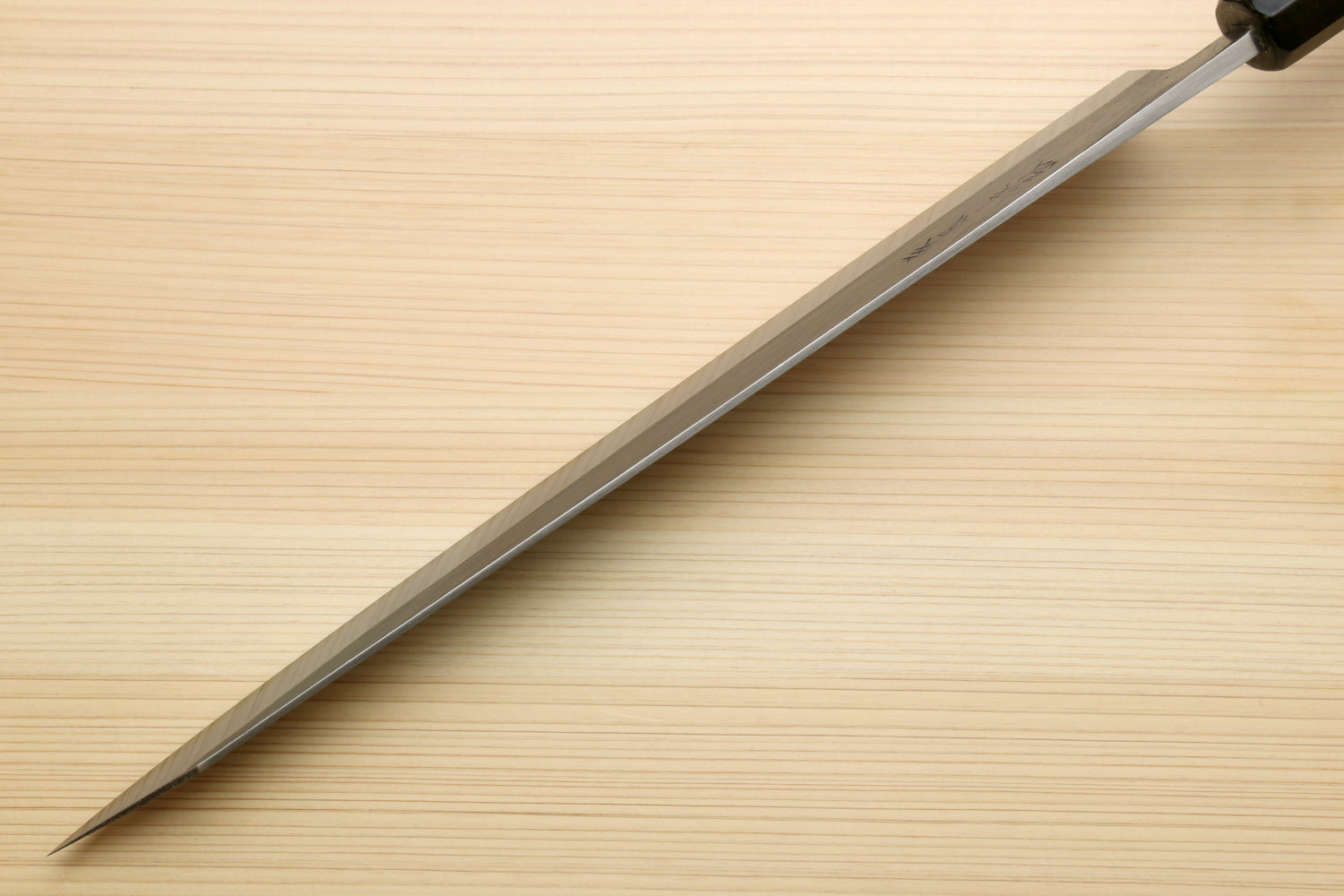 Sujihiki slicer knife in profile with long silver blade and dark ebony handle.