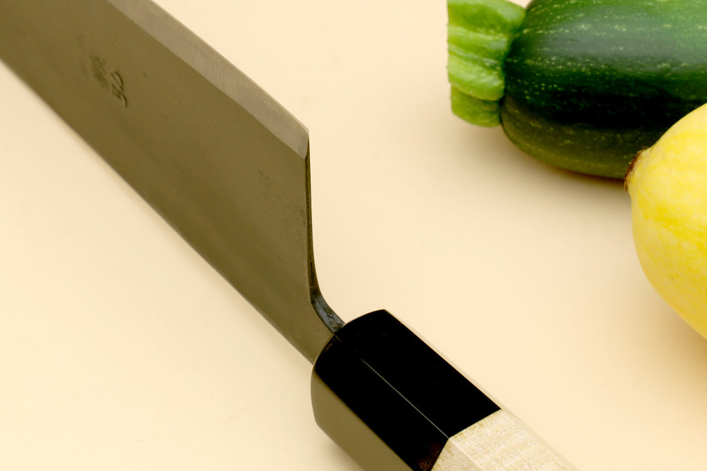 Gyuto chef knife heel close-up with pale camphor handle and black ferrule