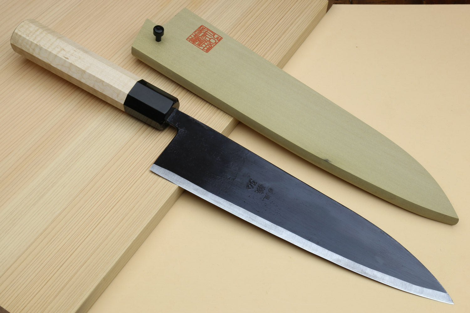 Gyuto chef knife with matching light sheath, pale camphor handle, dark blade