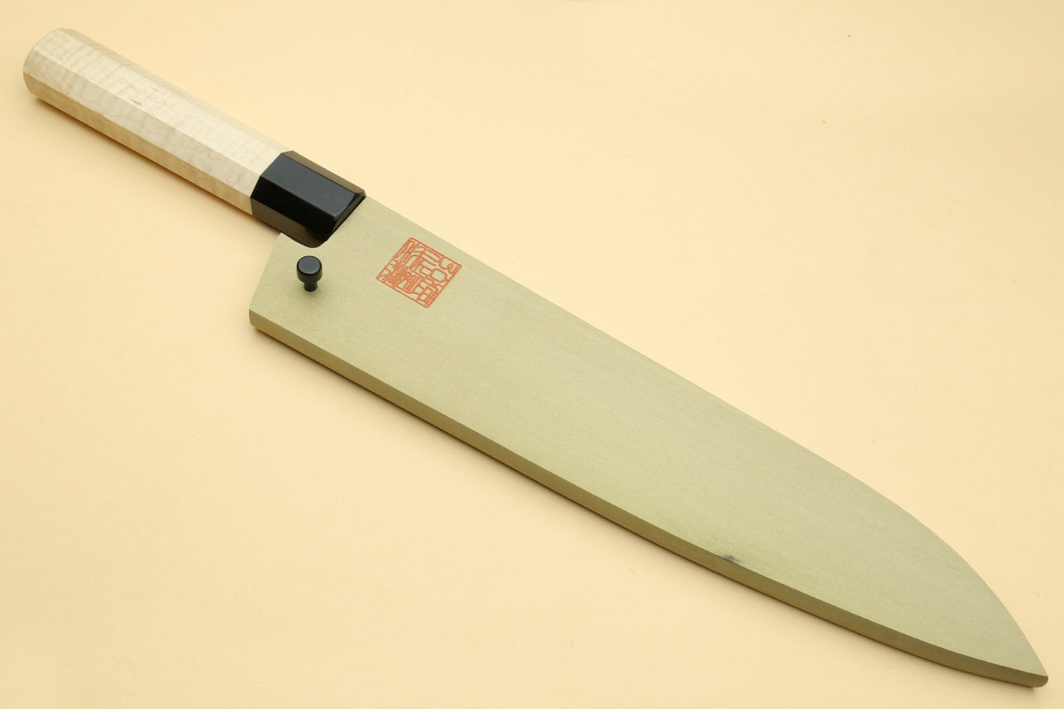 Gyuto chef knife with pale camphor wood handle and dark blade edge