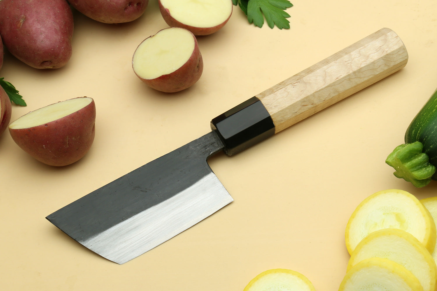Paring knife with dark blade and camphor wood handle.