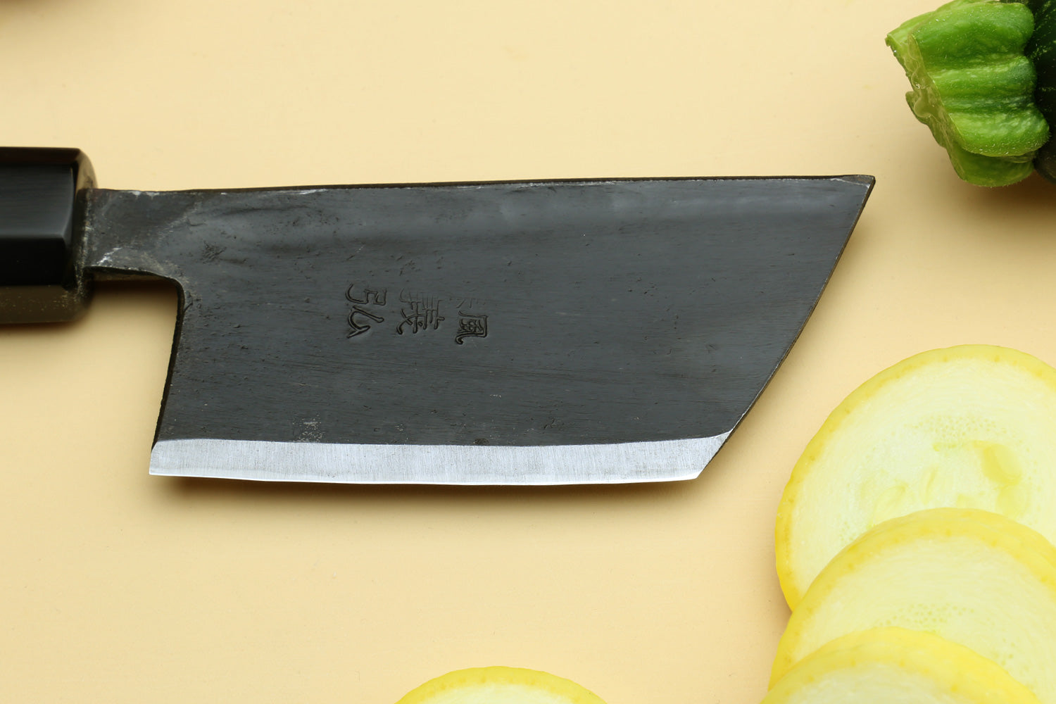 Paring knife with dark blade and camphor wood handle.