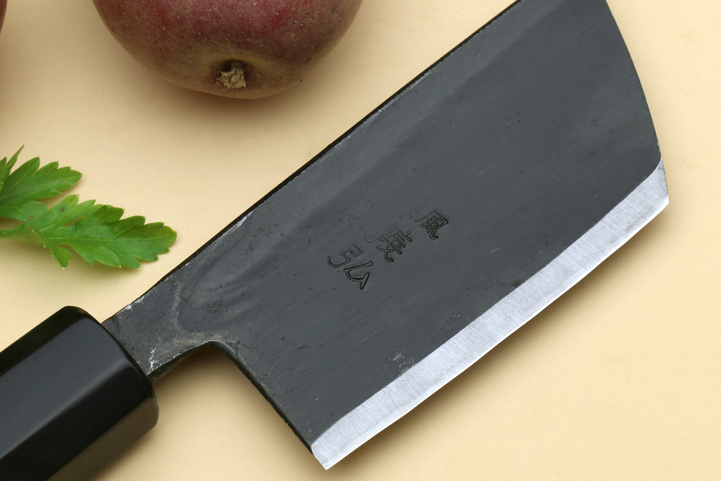 Paring knife blade close-up with dark steel finish.
