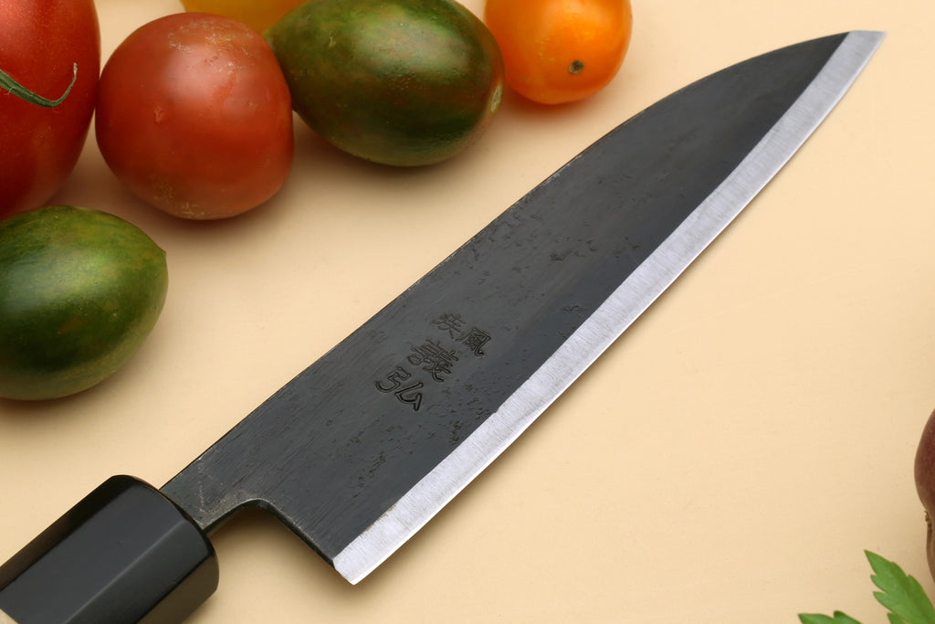Petty utility Japanese knife close-up of blade and black collar on camphor handle