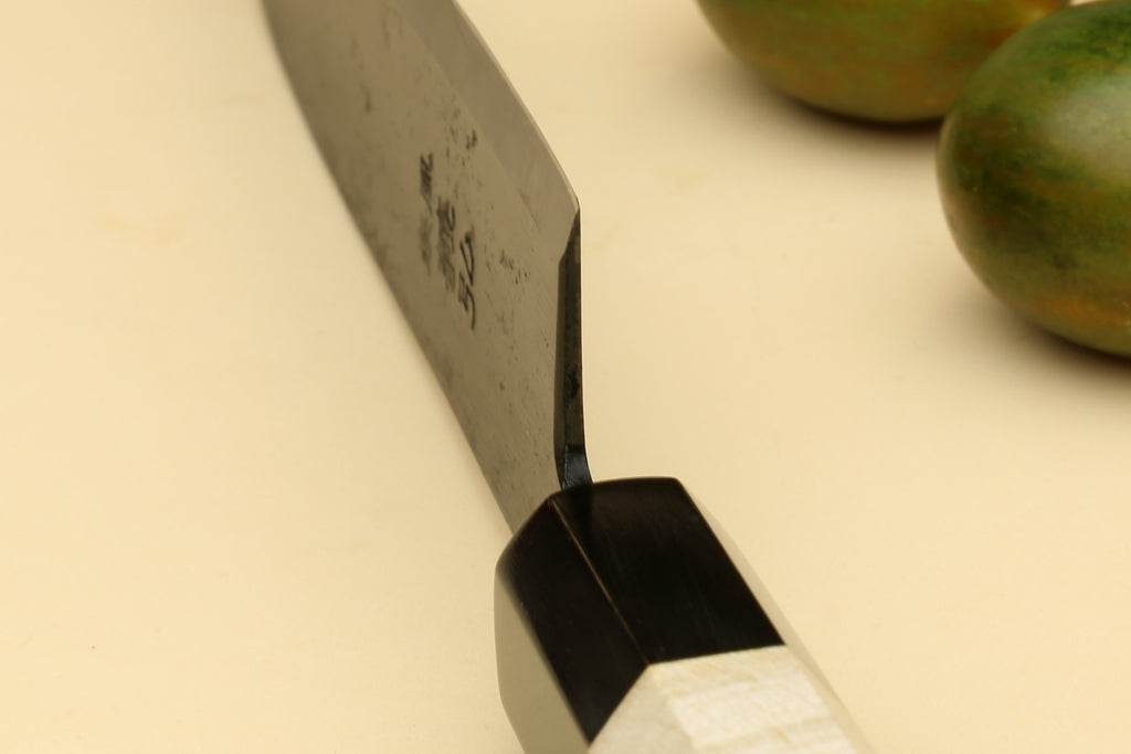 Petty utility Japanese knife, close view of dark handle collar and blade spine